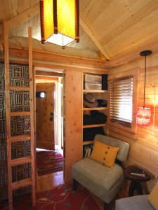 Interior of a small home with a loft bed by Jay Shafer